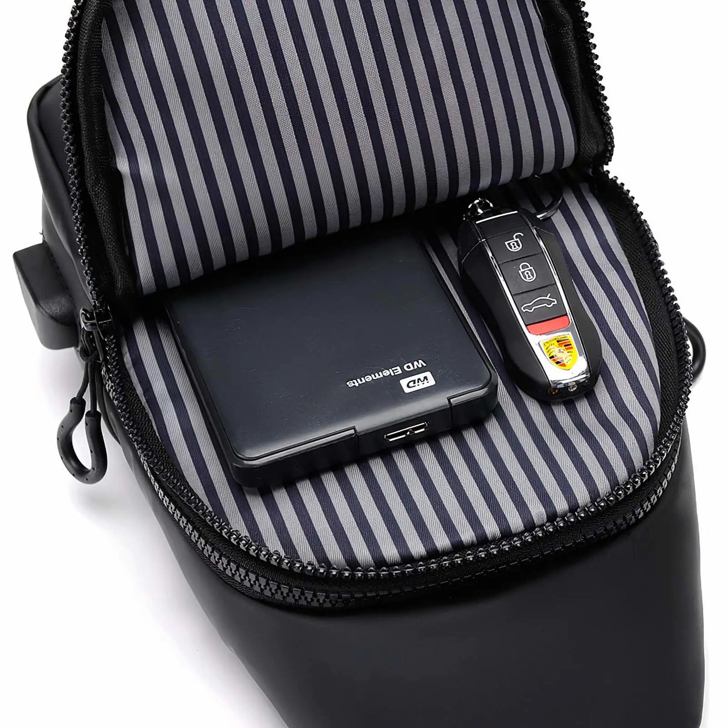 Sleek crossbody sling bag with hidden zippers, USB charging port, and adjustable strap.
