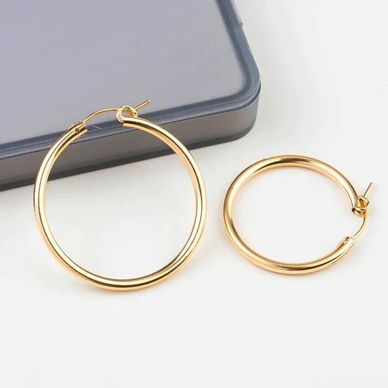 Polished yellow gold 585 oval hoop earrings by QIAO, lightweight and versatile for elegant style.