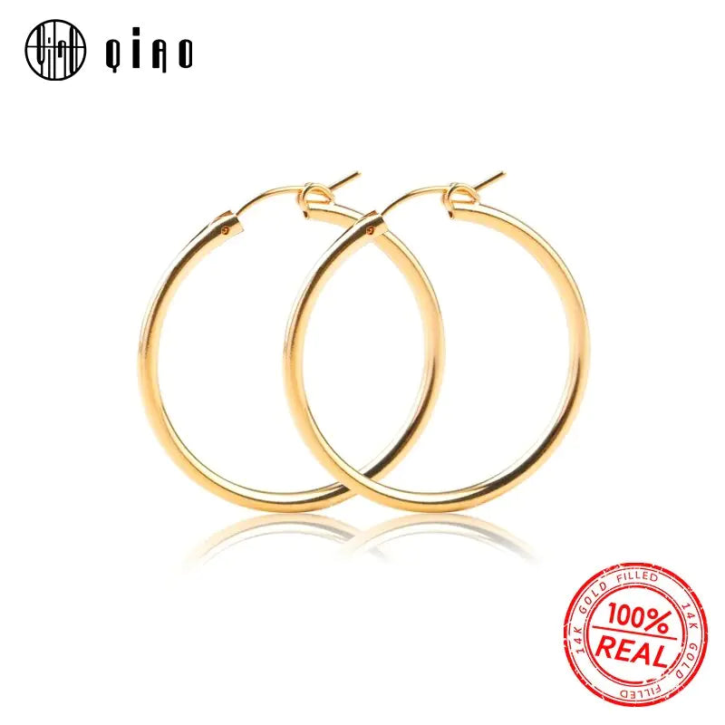 Polished yellow gold 585 oval hoop earrings by QIAO, lightweight and versatile for elegant style.