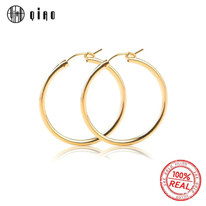 Polished yellow gold 585 oval hoop earrings by QIAO, lightweight and versatile for elegant style.